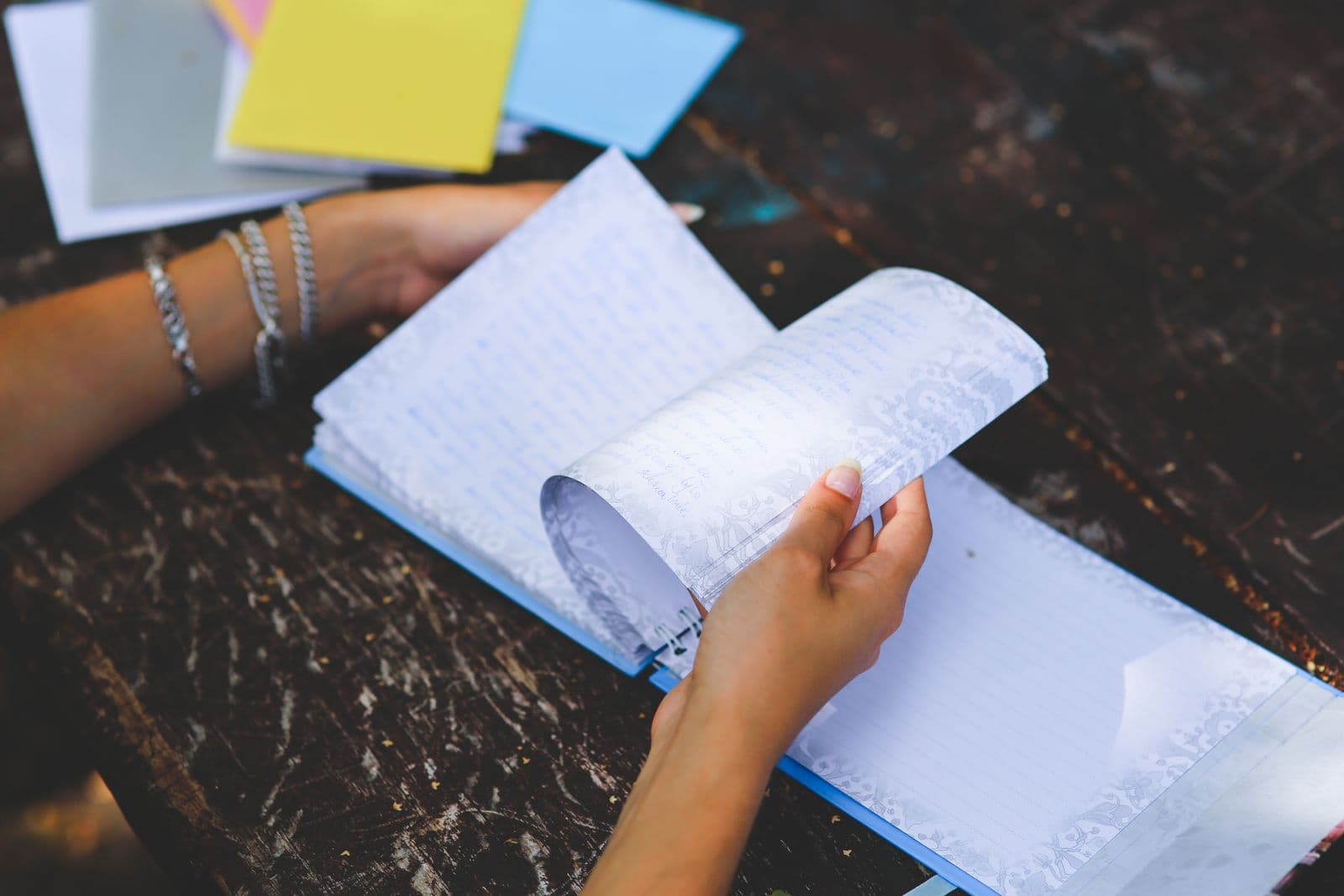 Hands turning the pages of a notebook